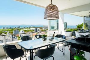 a dining room with a table and chairs on a balcony at Ocean Vue in Cape Town