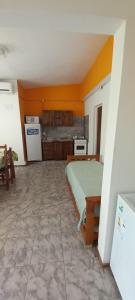 una camera con letto e una cucina con pareti arancioni di San blas departamento a San Blas