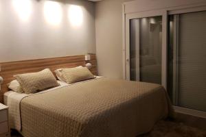 a bedroom with a bed and a walk in shower at Praia Xangri-lá Atlântida Capão da Canoa Torres in Xangri-lá +35 photos