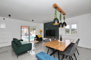 a dining room and living room with a table and chairs at Vila Beny in Vir