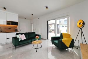 a living room with two green couches and a table at Vila Beny in Vir