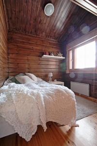 a bedroom with a bed and a wooden wall at Villa Sol Tahko in Tahkovuori