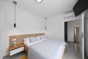 a bedroom with a white bed with a wooden headboard at Vila Beny in Vir +49 photos