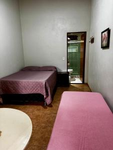 a bedroom with a bed and a table and a mirror at Sítio Matinha - Chap dos Veadeiros - São João dAliança in São João da Aliança
