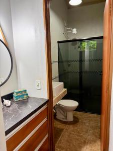a bathroom with a toilet and a glass shower at Sítio Matinha - Chap dos Veadeiros - São João dAliança in São João da Aliança +18 photos