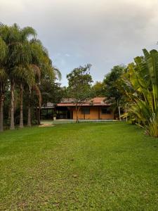 a building with palm trees in front of a yard at Sítio Matinha - Chap dos Veadeiros - São João dAliança in São João da Aliança