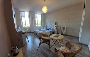 a room with two beds and a table and chairs at La Belle Etoile in Saintes