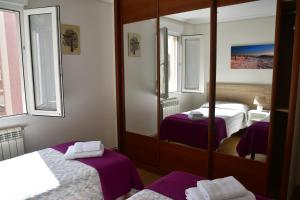 a hotel room with two beds and a mirror at Piso centro Santander - Parking Gratuito in Santander
