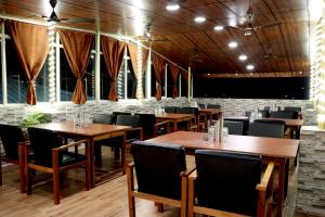 a dining room with wooden tables and chairs at Golden View Hotel in Port Blair