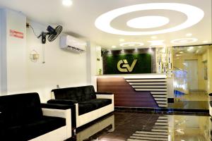 a lobby with two couches and a sign on the wall at Golden View Hotel in Port Blair