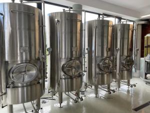 a row of silver tanks in a brewery at Zakarczmie Browar Wiejski in Leżajsk