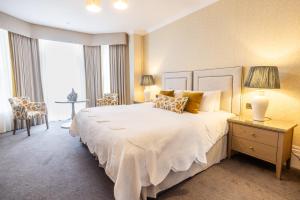 a bedroom with a large white bed with yellow pillows at Best Western Plus The Connaught Hotel and Spa in Bournemouth