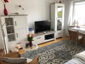 a living room with a tv and a couch at Wattlöwe ruhige Ferienwohnung mit Terrasse nahe Eider & Deich in Tönning