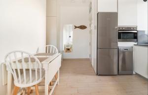 a kitchen with a table and a refrigerator at Apartamento con vistas a la playa in Santander