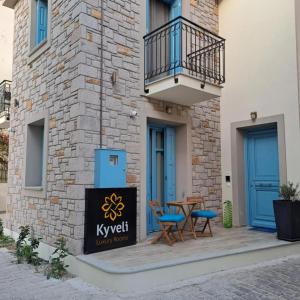 a patio with two chairs and a table in front of a building at Kyveli LuxuryRooms in Mirina