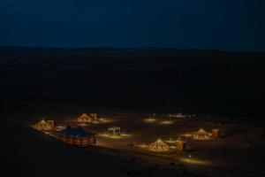a group of tents in the desert at night at Infinity Camp in Bidiyah