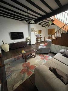 ein Wohnzimmer mit Sofa und Fernseher in der Unterkunft Casona histórica del S XVII en Novales in Novales
