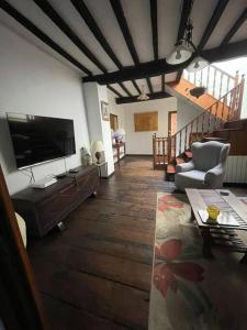 ein Wohnzimmer mit einem Flachbildfernseher an der Wand in der Unterkunft Casona histórica del S XVII en Novales in Novales + 35 Fotos