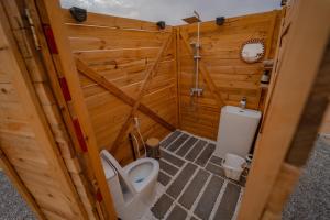 a bathroom with a toilet in a wooden wall at Infinity Camp in Bidiyah