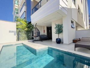 a house with a swimming pool and a building at 302 AR Dpto 3 dormitorios a 150m de la playa in Governador Celso Ramos