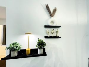 un mur avec deux étagères avec des plantes et une lampe dans l'établissement HolidayHome Apartments I Spacious 130qm Apartment Near Berlins Top Sights, à Berlin