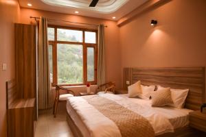 a bedroom with a large bed and a window at Zankhrpas A Himalayan Home - Manali in Manāli