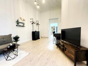 un salon avec une télévision à écran plat et un canapé dans l'établissement HolidayHome Apartments I Spacious 130qm Apartment Near Berlins Top Sights, à Berlin 38 autres photos
