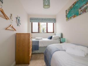 a bedroom with two beds and a window at The Beach Hut in Newquay