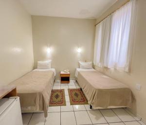 two beds in a room with a window at Hotel Ibiá in Montenegro +37 photos