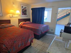 a hotel room with two beds and a staircase at Carpet Inn in Opelika