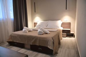 a bedroom with a bed with two towels on it at Valia's Elegance Stays in Alexandroupoli