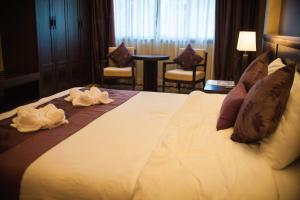 Panya Resort Hotel في أودون ثاني: غرفة فندق عليها سرير وفوط