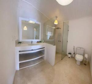 a white bathroom with a sink and a toilet at Apartamento Natureza Pipa Privilege in Pipa