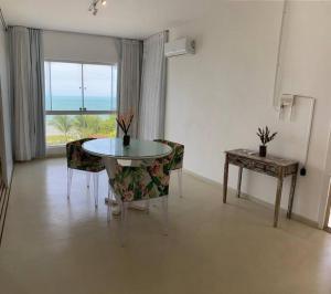 a dining room with a table and chairs and a window at Apartamento Natureza Pipa Privilege in Pipa +3 photos