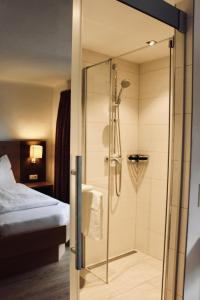 a shower with a glass door in a hotel room at Pension Auwirt Saalbach in Saalbach-Hinterglemm