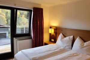 a hotel room with a bed and a window at Pension Auwirt Saalbach in Saalbach-Hinterglemm