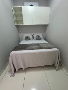 a small bedroom with a bed with white cabinets at Apê Serrano in Serra de São Bento