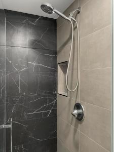 a bathroom with a shower with a black marble wall at Newly Remodeled full Apartment in Miami