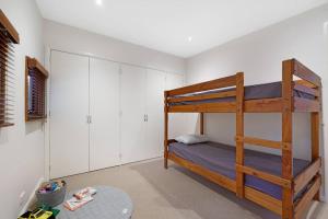 a bedroom with a bunk bed and white cabinets at Kurraburra Lodge in Anglesea