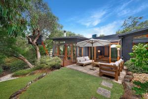 a house with a patio and an umbrella at Kurraburra Lodge in Anglesea