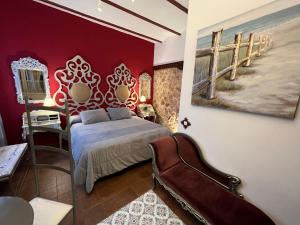 Un dormitorio con una cama y una pared roja. en Retiro del Teatro Almagro, en Almagro