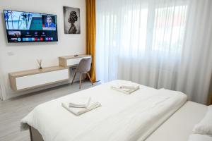 Un dormitorio con una cama y un televisor en la pared. en Zain Apartament, en Craiova
