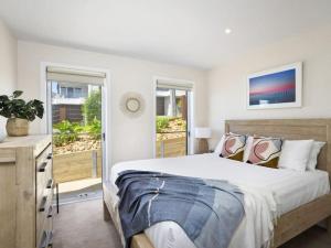 een slaapkamer met een groot bed en twee ramen bij Oceans 10 in Ocean Grove