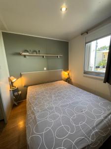 a bedroom with a large bed and a window at Bungalow à capbreton - Terrasse in Capbreton