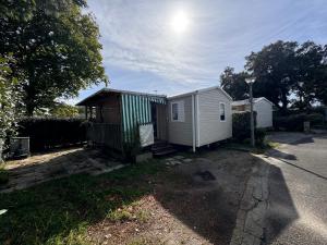 a small white shed sitting on the side of a street at Bungalow à capbreton - Terrasse in Capbreton