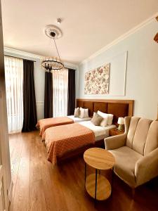 una camera d'albergo con due letti e un divano di Hotel Wine Time Tbilisi a Tbilisi City