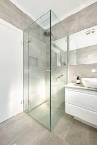 een badkamer met een glazen douche en een wastafel bij Bluff Vista in Ocean Grove