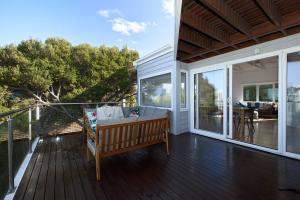 een veranda met een bank op een terras bij Bluff Vista in Ocean Grove