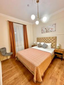 a bedroom with a bed and a chair at Hotel Wine Time Tbilisi in Tbilisi City