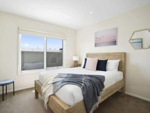 een slaapkamer met een groot bed en een raam bij Oceans 10 in Ocean Grove